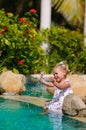 Cute toddler girl splashing in swimming pool