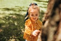 Cute toddler kid exploring the nature outdoors. Adorable little girl playing in the forest in the summertime. Curious child Royalty Free Stock Photo