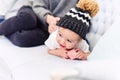 Cute toddler lies on the blue couch and happy young mommy kneading his legs and makes him happy. Royalty Free Stock Photo