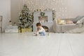 Cute toddler playing with his Christmas present in the decorated room. wooden toy. Family Xmas morning in decorated