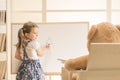 Cute toddler playing teacher role game with her toy