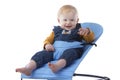 A cute toddler sits in a baby lounger and smiles on a white background