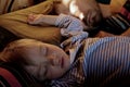 Cute toddler son and his father sleeping together on bed in bedroom at home. Real lifestyle family photo taken early morning. Royalty Free Stock Photo
