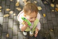 Cute toddler talking on a toy phone.