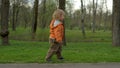 Cute toddler walking in park in slow motion. Small boy running outdoors Royalty Free Stock Photo