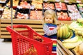 Cute todler girl pushing shopping cart in supermarket. Little child buying fruits. Kid grocery shopping. Adorable baby