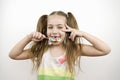 Cute toothless little girl with blue eyes eating lollipop