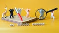 Cute toy dancing kittens and a funny giraffe, notepad, fountain pen and magnifying glass on a yellow background. The concept of a