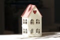 Cute toy house on a dark background. White decorative toy house in sunlight Royalty Free Stock Photo