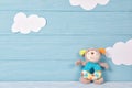 Cute toy puppy beanbag on a blue wooden background with white clouds, baby card Royalty Free Stock Photo