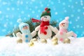 Cute toy snowmen, fir branch and Christmas balls on snow against blurred background Royalty Free Stock Photo