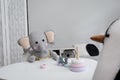 Cute toys at white table in child`s room. Interior design Royalty Free Stock Photo