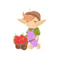 Cute troll boy character with wooden cart full of strawberries, funny creature cartoon vector Illustration