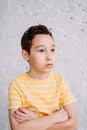 Cute tween indifferent sad boy in yellow t-shirt making kiss by hands isolated on the white wall background