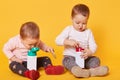 Cute twin sisters have a meal together without parents, play with each other, spend free time. One of the sisters wants to share Royalty Free Stock Photo