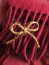 Cute twine bow hanging on colorful wool fringe.