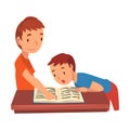 Cute Two Schoolboys Standing at Desk and Reading Book, Boy Helping his Younger Brother with Homework and Explaining Royalty Free Stock Photo