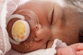 Cute two weeks old newborn baby girl with a pacifier Royalty Free Stock Photo