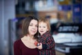 Cute two year old boy on mother`s hands during walk in public place Royalty Free Stock Photo