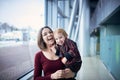 Cute two year old boy on mother`s hands during walk in public place Royalty Free Stock Photo