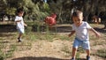 Cute two years old boy and his brother four year old running in the empty park. Social distancing, 2020