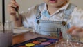 Cute two years old boy painting with water colours