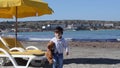 Cute two years old boy with teedy bear on the sandy beach colder weather