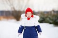 Little cute unhappy toddler girl outdoors on a sunny winter day. Royalty Free Stock Photo