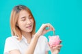 Cute university Asian teen girl happy saving money with smile piggy bank Royalty Free Stock Photo