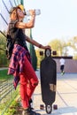 Cute urban girl holding skateboard