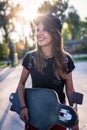 Cute urban girl holding skateboard