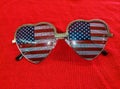 Cute USA Flag sunglasses laying on a red knit sweater - Showing Patriotism - Stars in your eyes Royalty Free Stock Photo