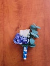 Cute wedding boutonniere with white and violet flowers in wooden background Royalty Free Stock Photo