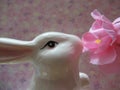 Cute white bunny rabbit figurine and artificial pink plum blossom flowers