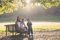 Cute white family in the park - a little boy blowing soap bubbles and his parents watching him Royalty Free Stock Photo