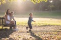 Cute white family in the park - a little boy chasing soap bubbles and his parents watching him Royalty Free Stock Photo