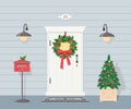 Cute white front door with Christmas wreath, lanterns, Christmas tree and mailbox Royalty Free Stock Photo