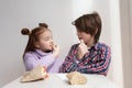 Cute white kids looking at each other while eating fries in a fast food restaurant. Couple of adorable elementary age children Royalty Free Stock Photo