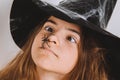 Girl`s face in witch hat with spider halloween middle look Royalty Free Stock Photo