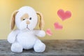 Cute white puppy doll sitting on the wooden chair showing red heart Royalty Free Stock Photo