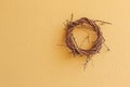 Cute wicker wooden wreath made of dried branch hanging on yellow Royalty Free Stock Photo