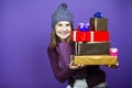 Cute Winsome Laughing Caucasian Adult Female in Seasonal Warm Clothing Posing with Big Wrapped Present Gift Boxes And Smiling