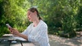 Cute woman answering message smartphone sitting nature recreation place close up Royalty Free Stock Photo