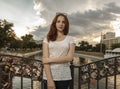 Cute woman on bridge with love locks on fence looking at camera Royalty Free Stock Photo