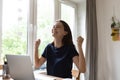 Cute woman celebrate great news read on laptop