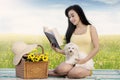 Cute woman and dog read book at field Royalty Free Stock Photo