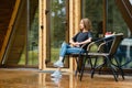 Cute woman enjoys fresh air after the rain in forest cabin