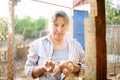 Cute woman farmer collecting fresh organic eggs on chicken farm. Floor cage free chickens is trend of modern poultry farming. Royalty Free Stock Photo