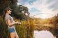 Cute woman is fishing with rod on lake Royalty Free Stock Photo