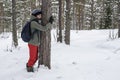 A woman is hugging a tree in a winter forest. The concept of con Royalty Free Stock Photo